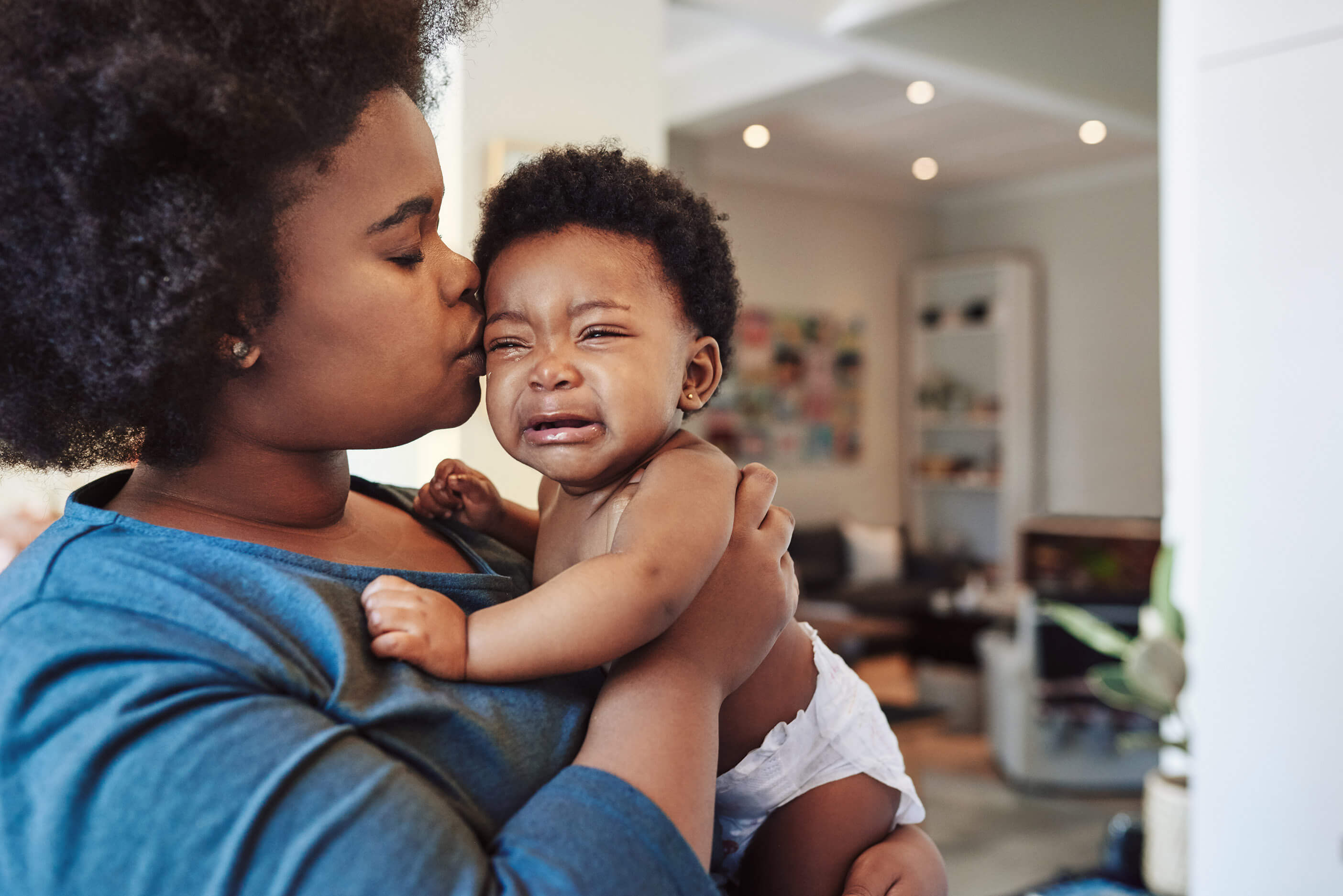 A woman holding her crying infant