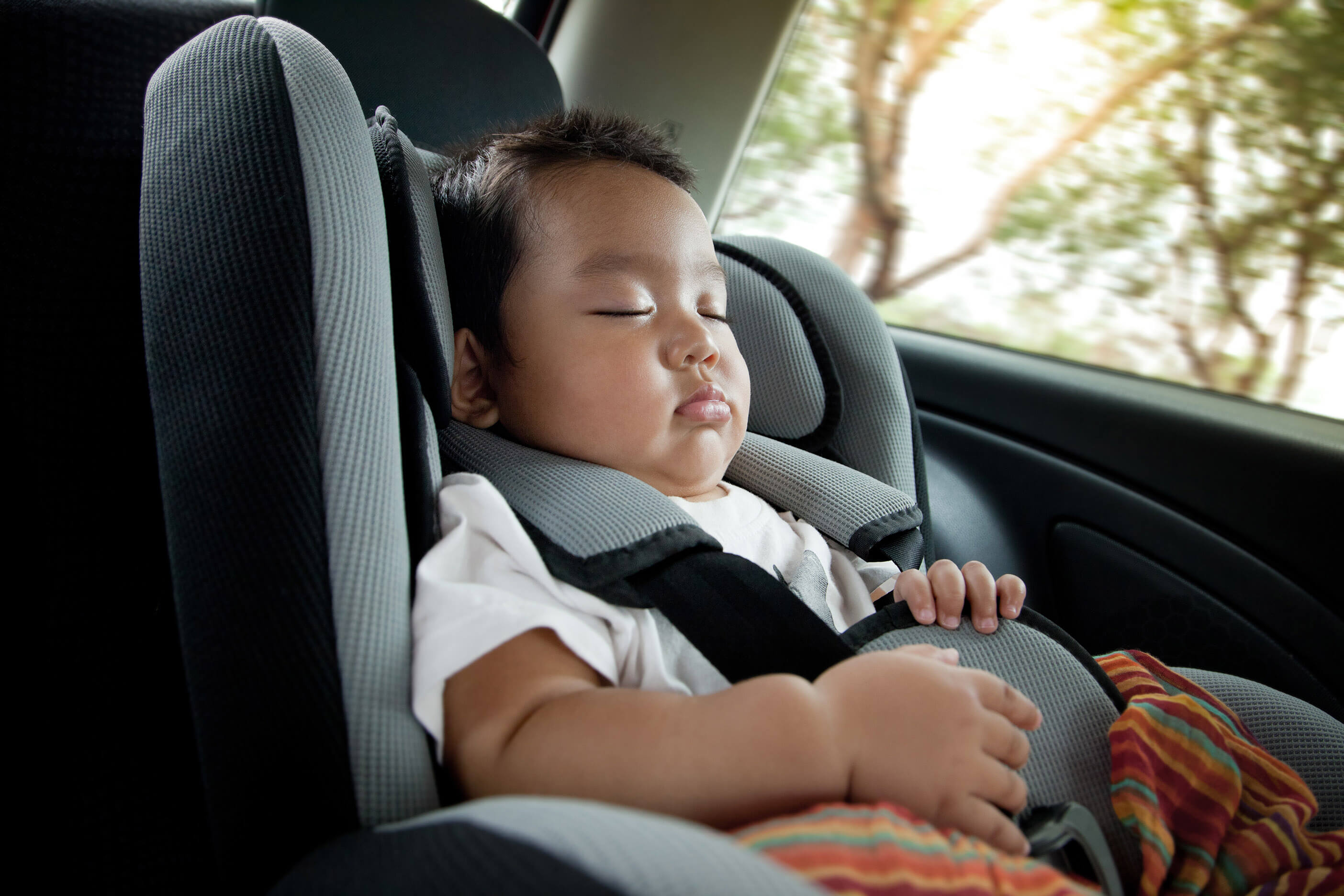 An infant safely sleeping in car seat