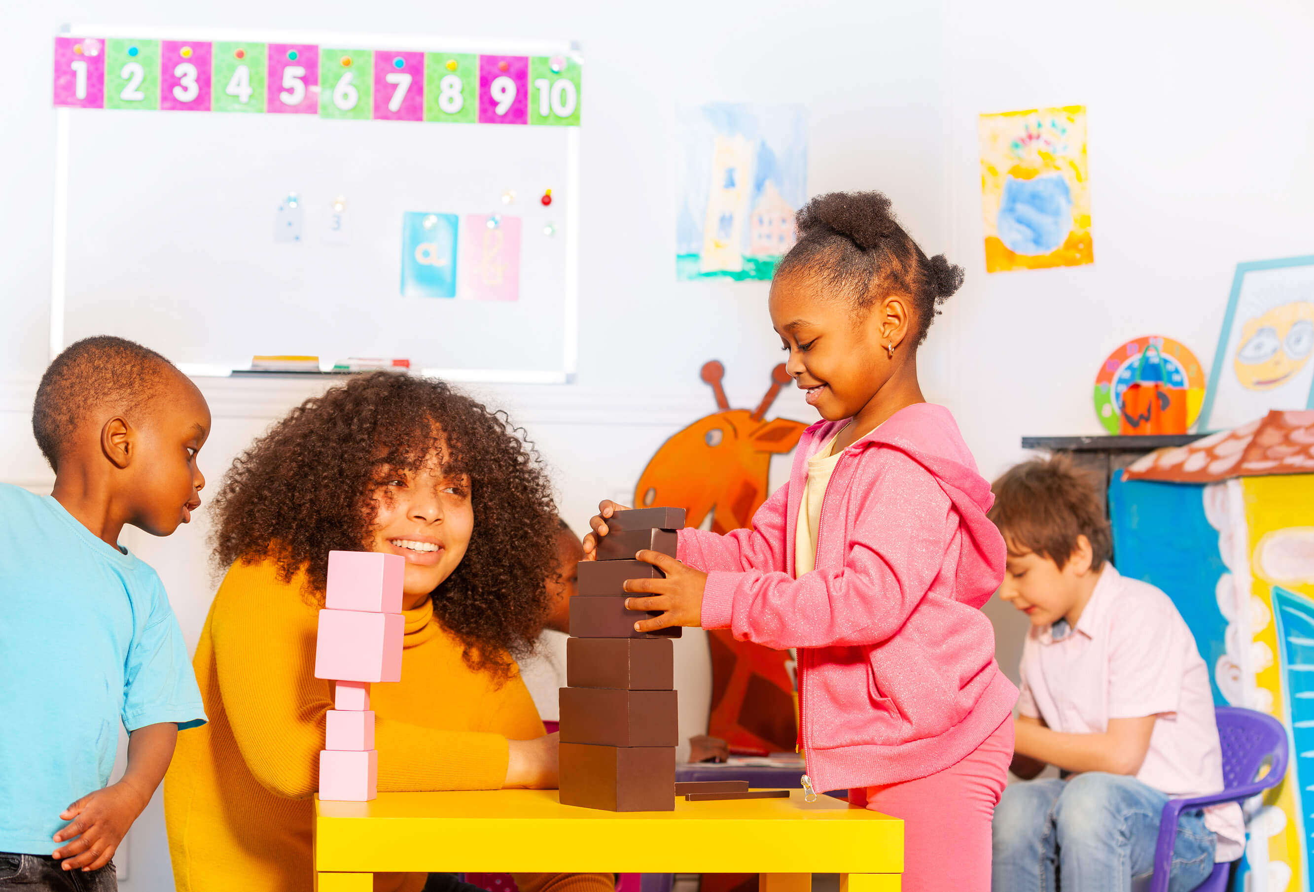 Preschools sitting at a table playing with blocks