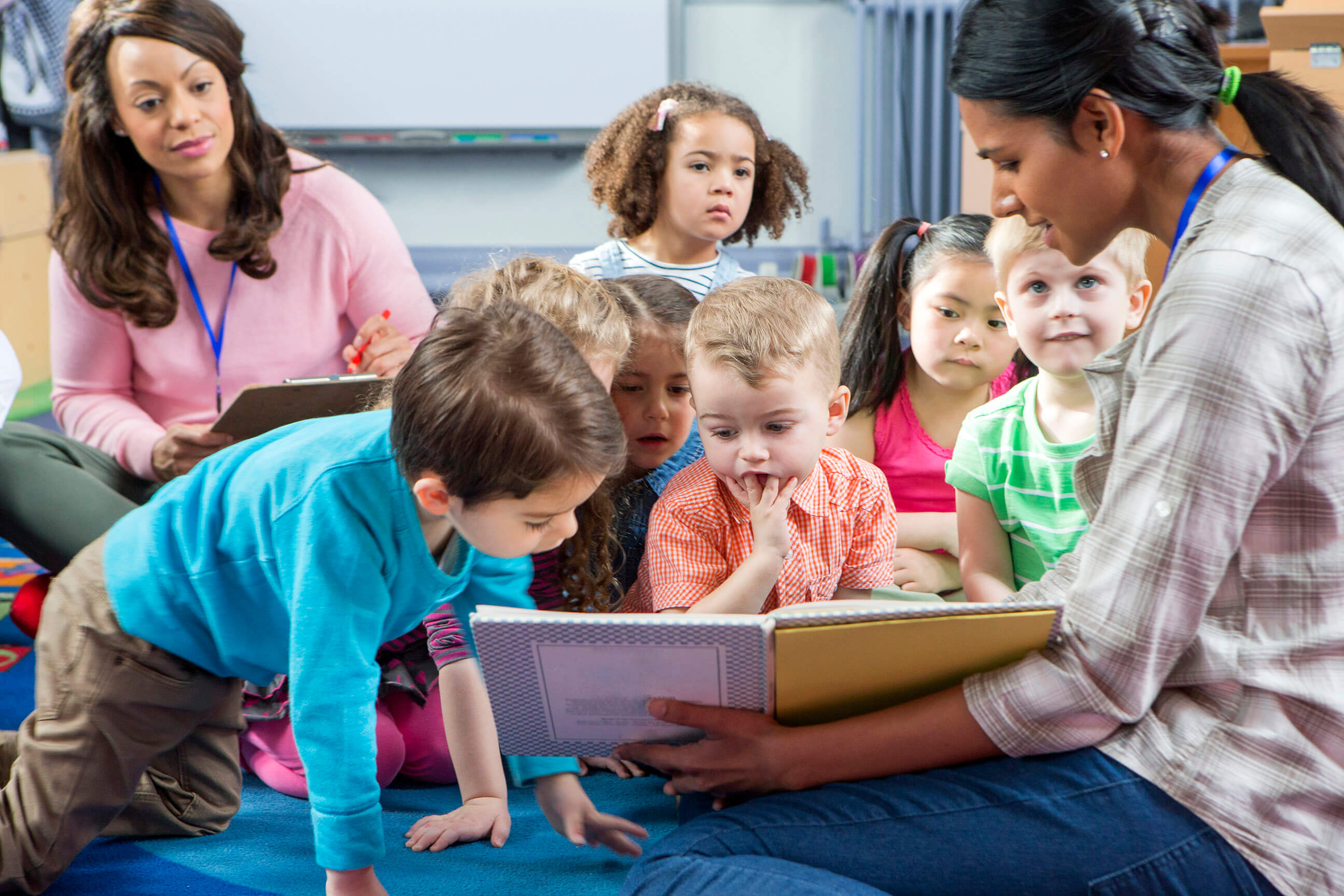 Proveedor de cuidado infantil leyendo a los estudiantes