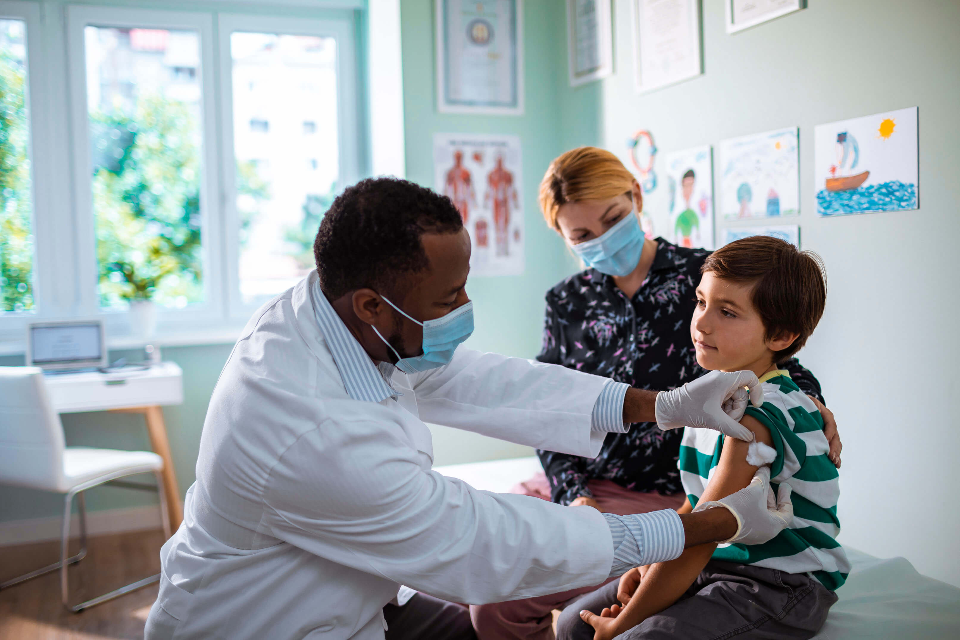 Un niño recibiendo una vacuna por parte del médico.