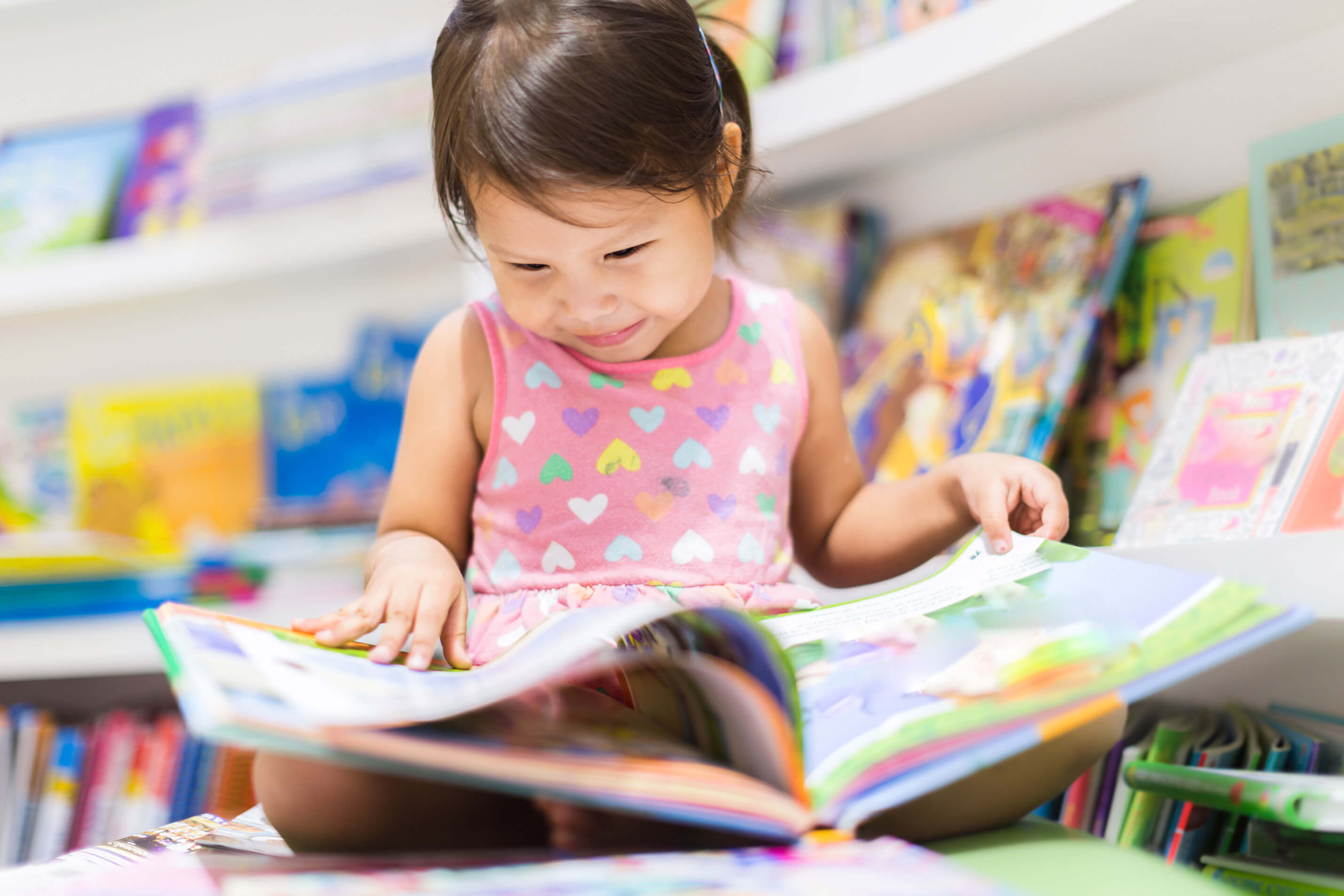 Child sitting on the floor reading a book