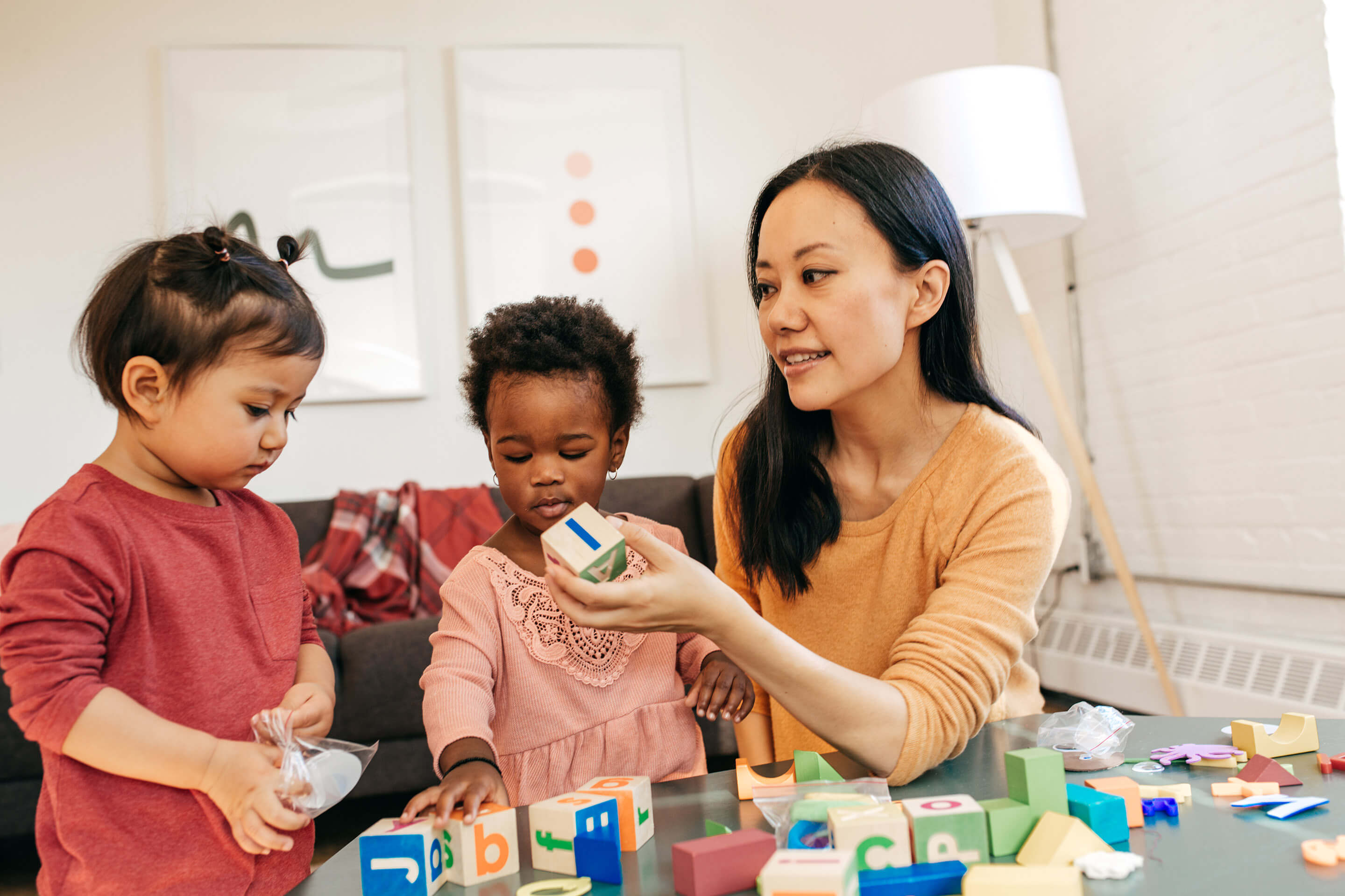 Child care provider playing with toddlers